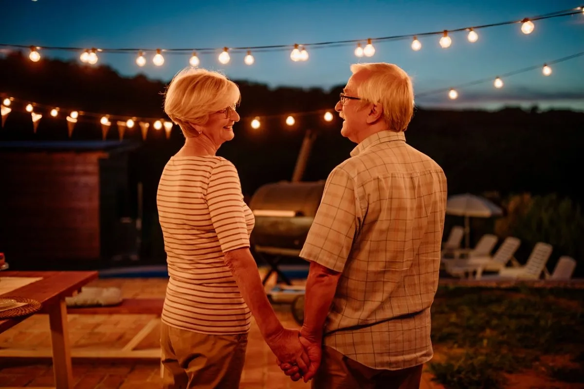 Retired man and woman holding hands