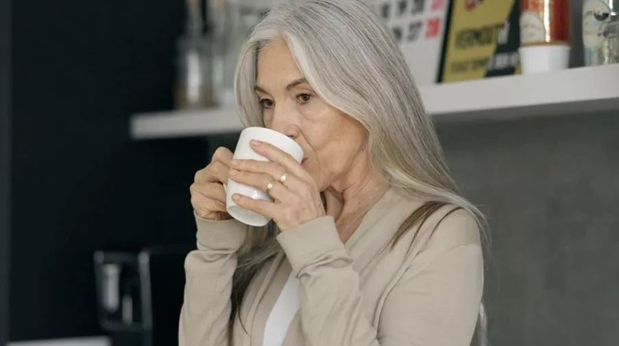 Middle aged woman drinking from a mug