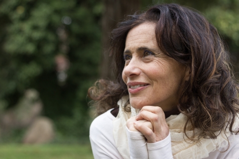 Cheerful middle aged pretty lady in the park thinking