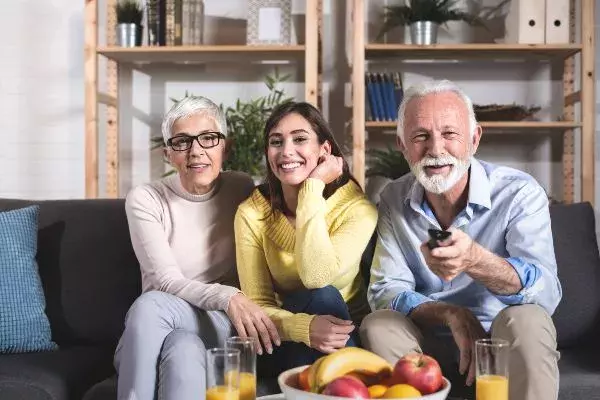 senior couple sit on the sofa with younger woman