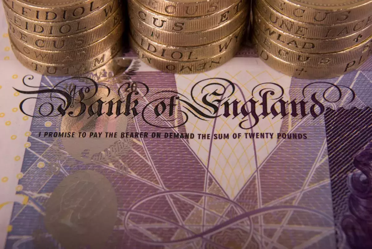 Row of coins over a twenty pound note