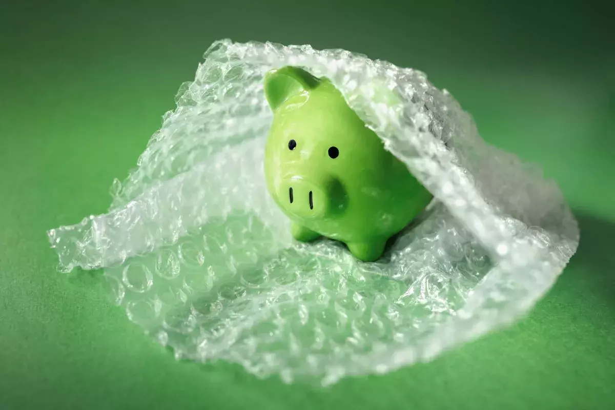 Green piggy bank in bubble wrap