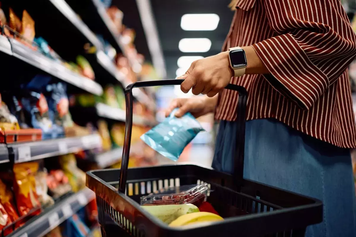 Close up of woman with shopping basket buying groceries at the store
