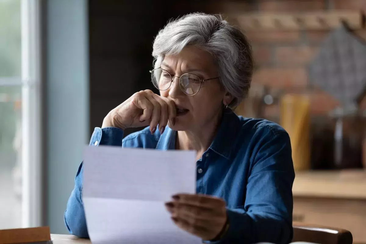 old age female check a letter at home