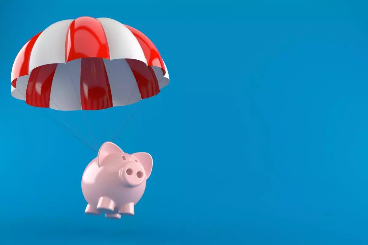 Piggy bank with parachute isolated on blue background