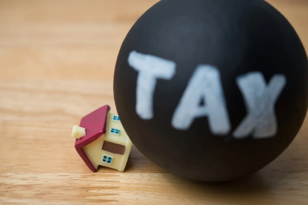 Heavy tax crash the house model on wooden table background