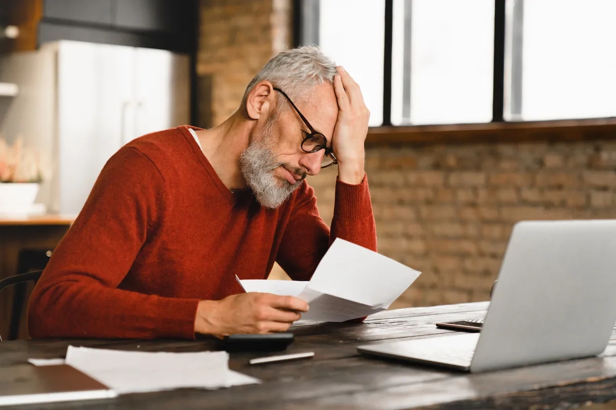 Sad depressed Caucasian businessman holding documents
