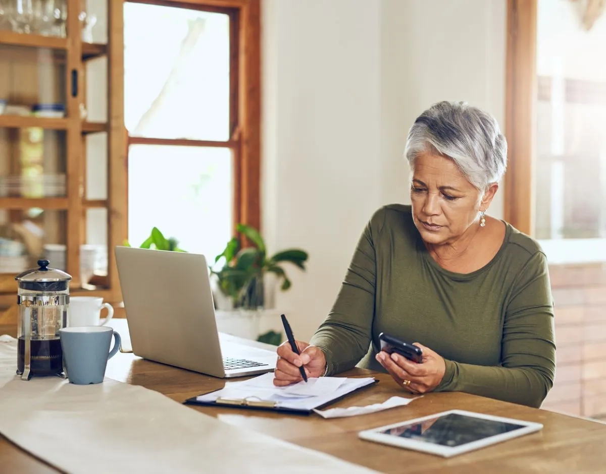 Lady looking at bills, using a calculator