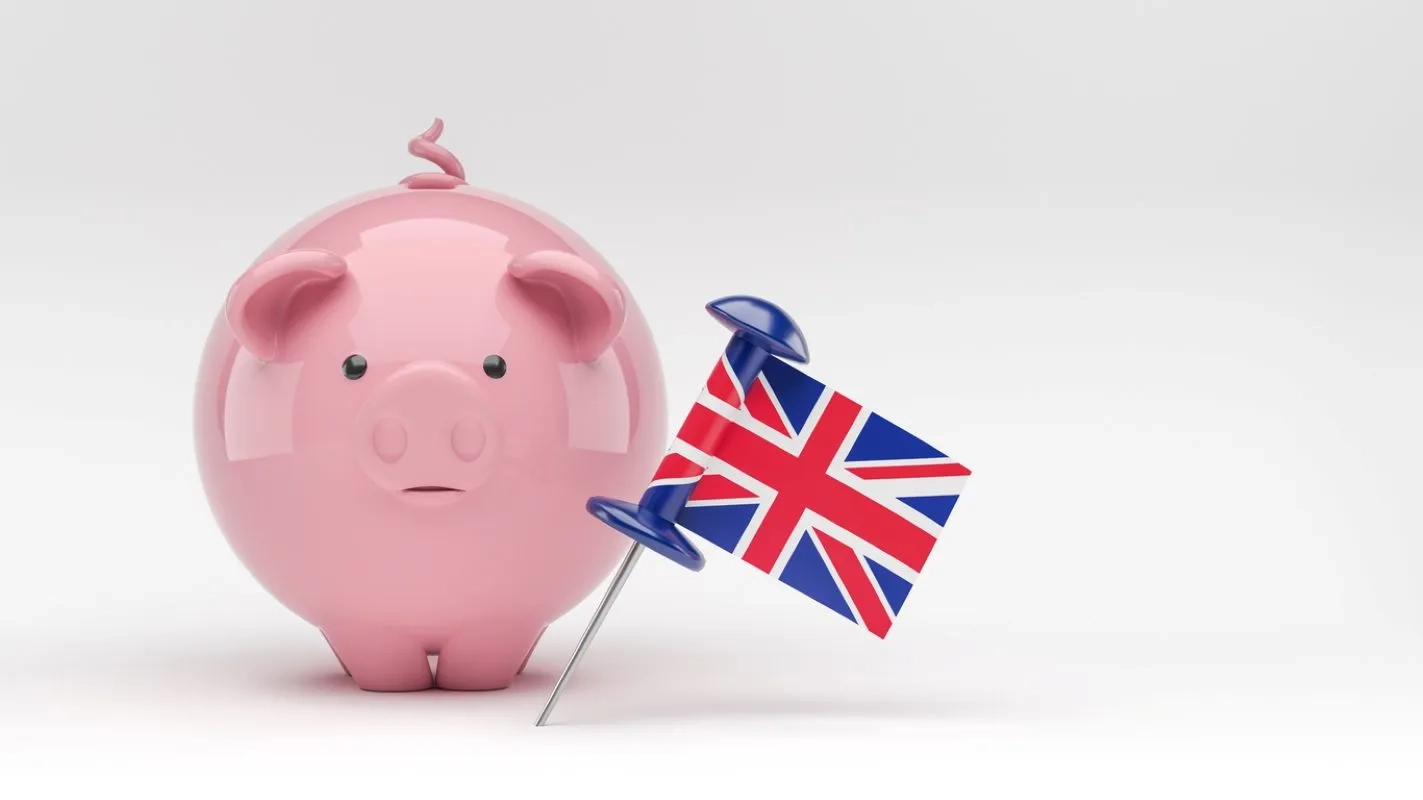 Piggybank and the English flag. On white color background. Isolated with clipping path