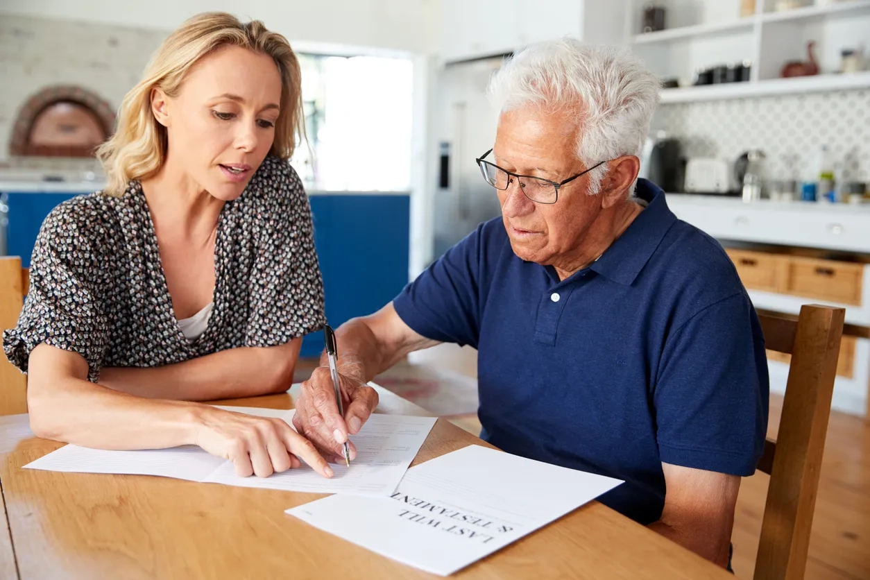 Woman helping senior man to complete paperwork