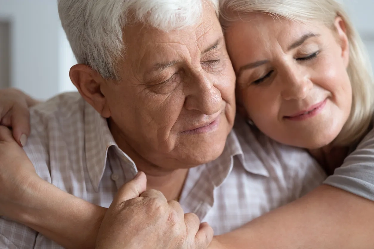 Middle aged woman and father embracing