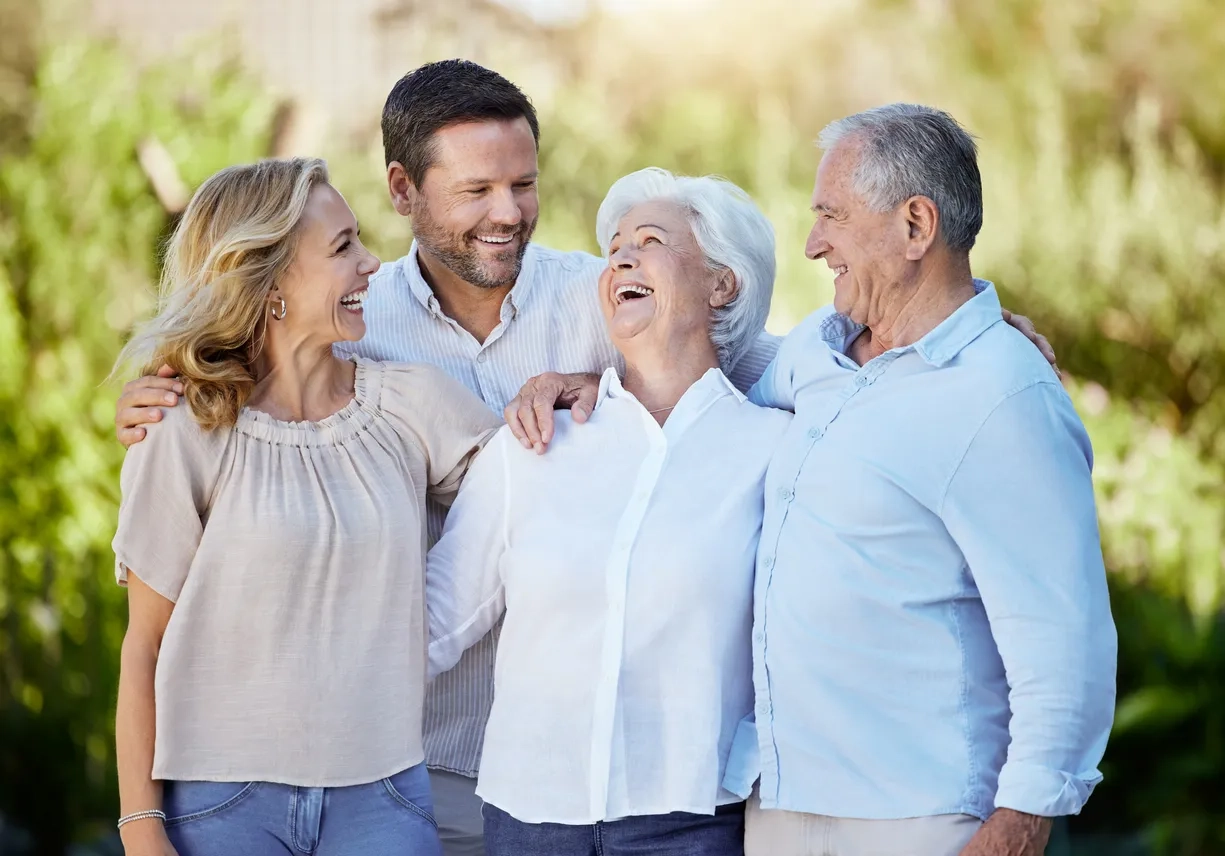 Elderley couple with adult children laughing and looking at eachother