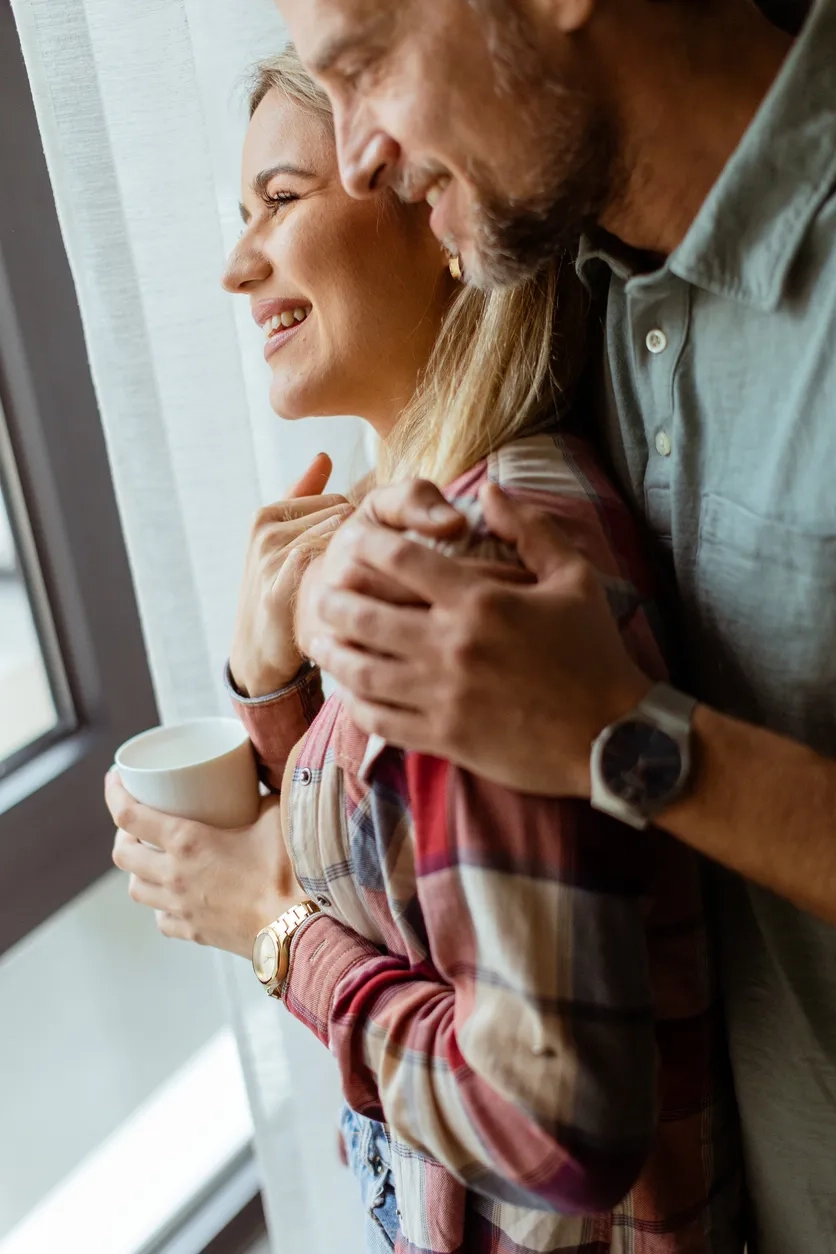 Middle aged man and woman looking out of the window
