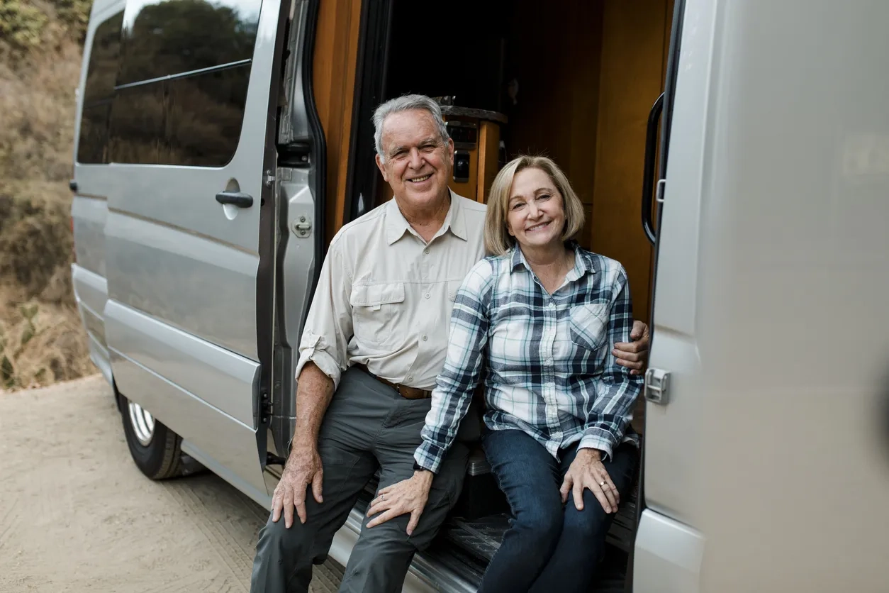 Senior couple sat inside a campervan 
