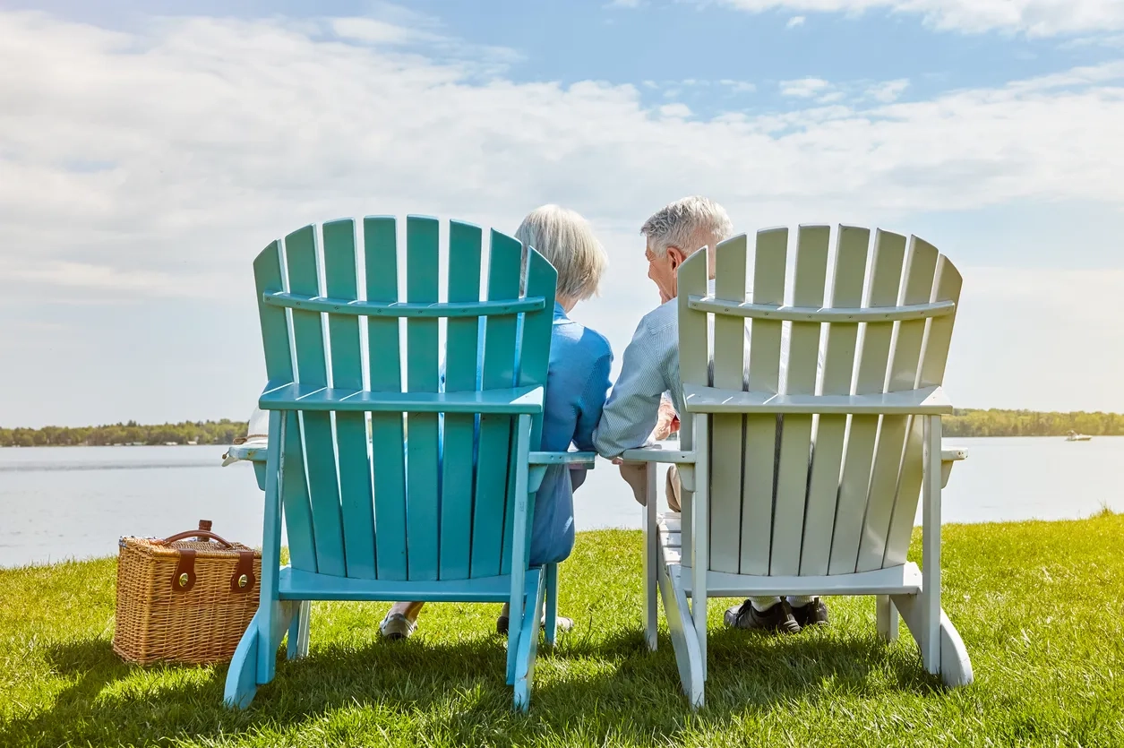 Retired couple in a blue and white chair by the sea