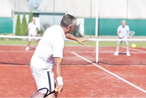 older man playing tennis