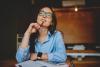 woman in blue shirt pondering just how long term investments should be to mature