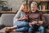 senior couple sat on the sofa in a modern room reading books