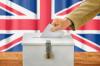Man putting a ballot into a voting box
