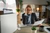 Mature woman lost her job fired from work pack personal items in box and reading letter