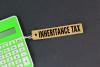 green calculator and a paper tag with the words Inheritance