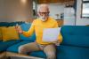 One senior man grandfather with beard and eyeglasses at home solving problem worried frustration