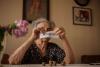 Portrait of female pensioner tearing paper with the word pension