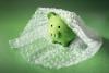 Green piggy bank in bubble wrap