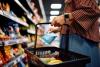 Close up of woman with shopping basket buying groceries at the store