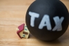 Heavy tax crash the house model on wooden table background
