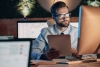 Confident young man working on computer while staying late in the offic