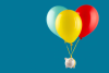 piggy bank attached to balloons rising into the air