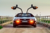  DeLorean DMC-12 car with opened gullwing doors parked on the bridge at dusk