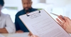 Hand, document or testament in office by closeup for last will, insurance of funeral planning for family futur